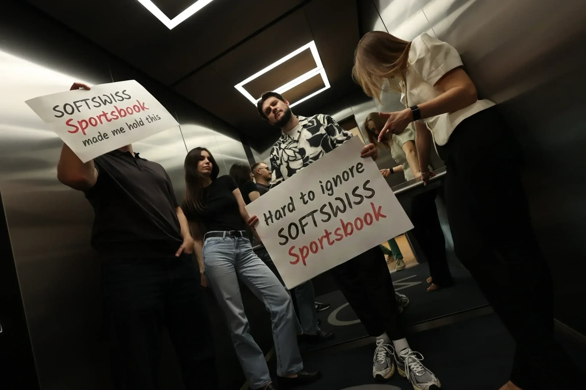 Employees hold promotional signs featuring products beyond the main Casino Platform