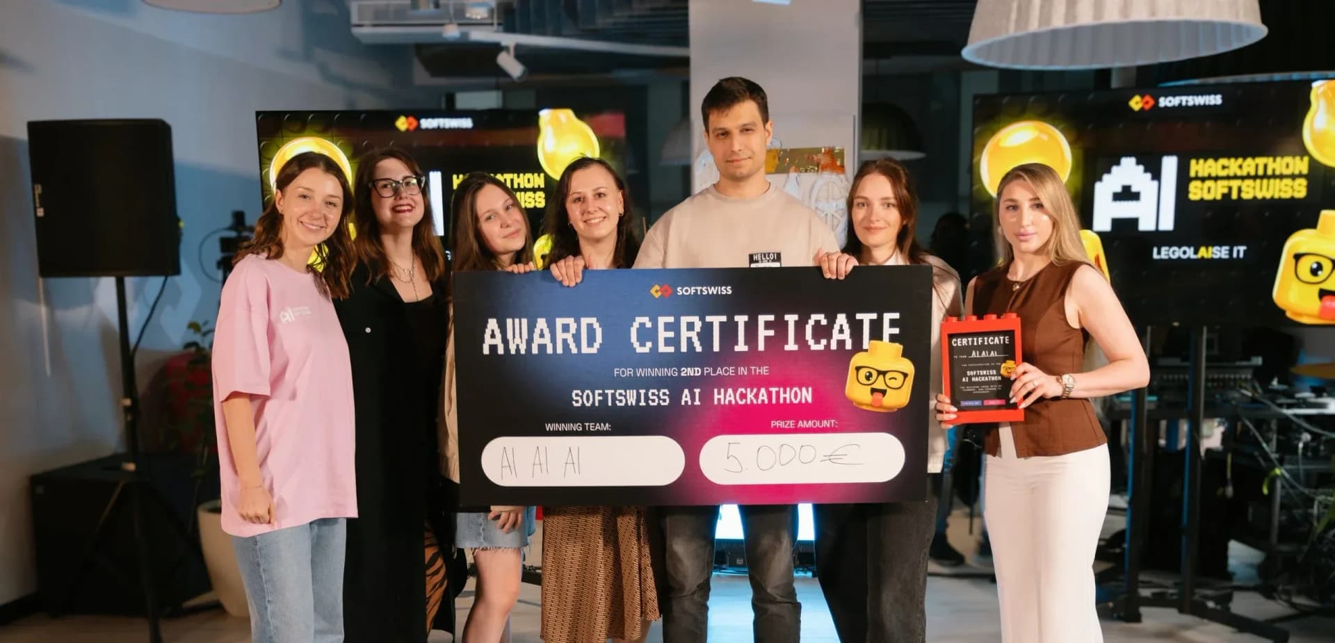 Seven hackathon participants holding certificates at awards ceremony
